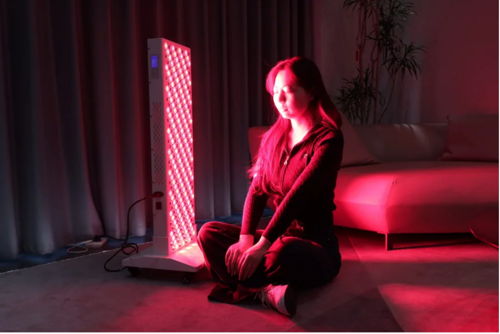 A woman using red light therapy equipment